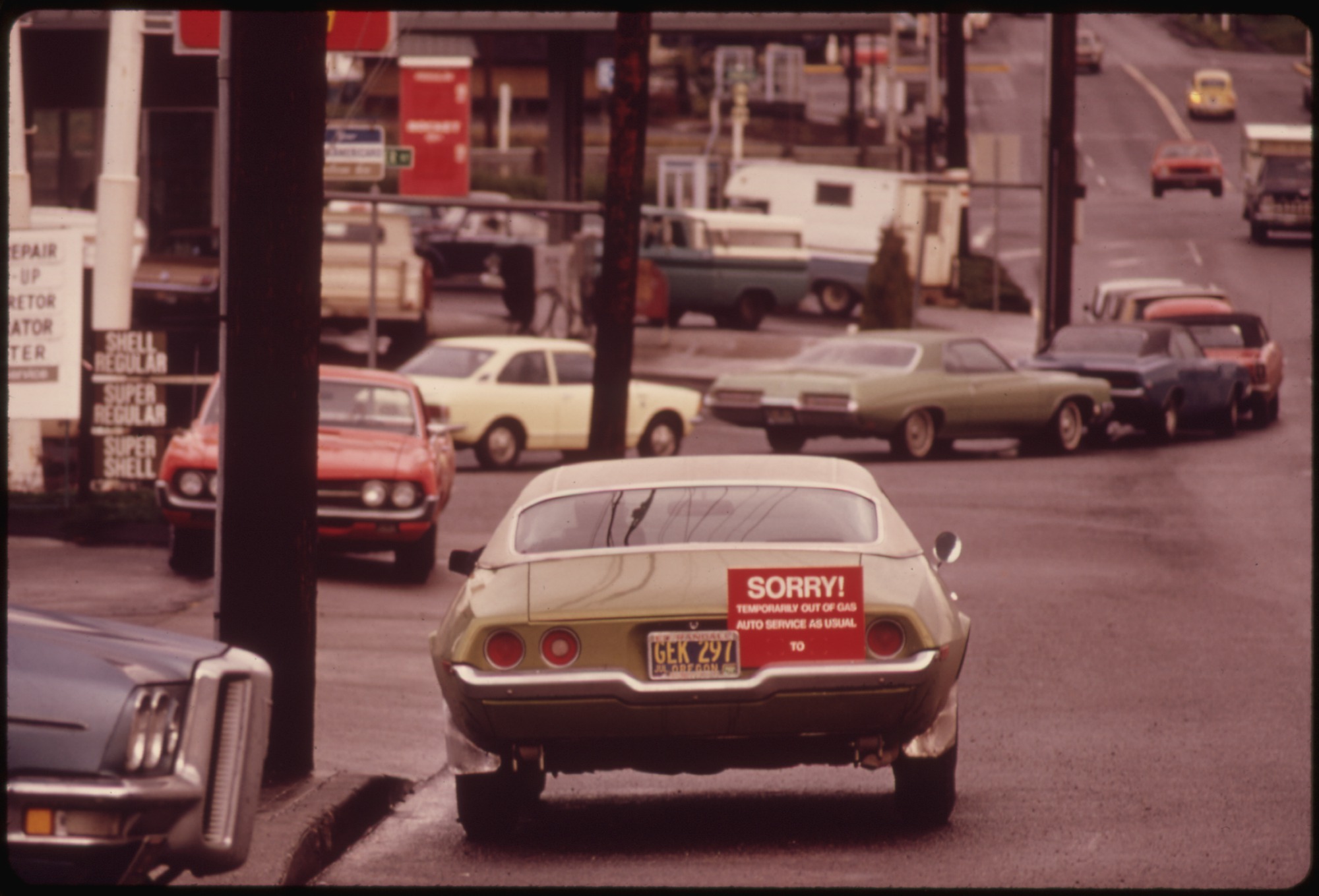 Cars wait in a Portland gasoline line in December 1973. A red sign on the final car says the station is temporarily out of gas, indicating that cars behind it will not receive fuel.